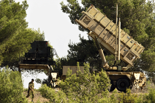 C_NB-An-Israeli-soldiers-walks-near-a-Patriot-surface-to-air-missile-battery-as-it-is-deployed-in-Mount-Carmel,-in-the-northern-coastal-city-of-Haifa,-on-October-9,-2012,-two-days-after-an-unmanned-aerial-vehicle-(UAV)-breached-Israeli