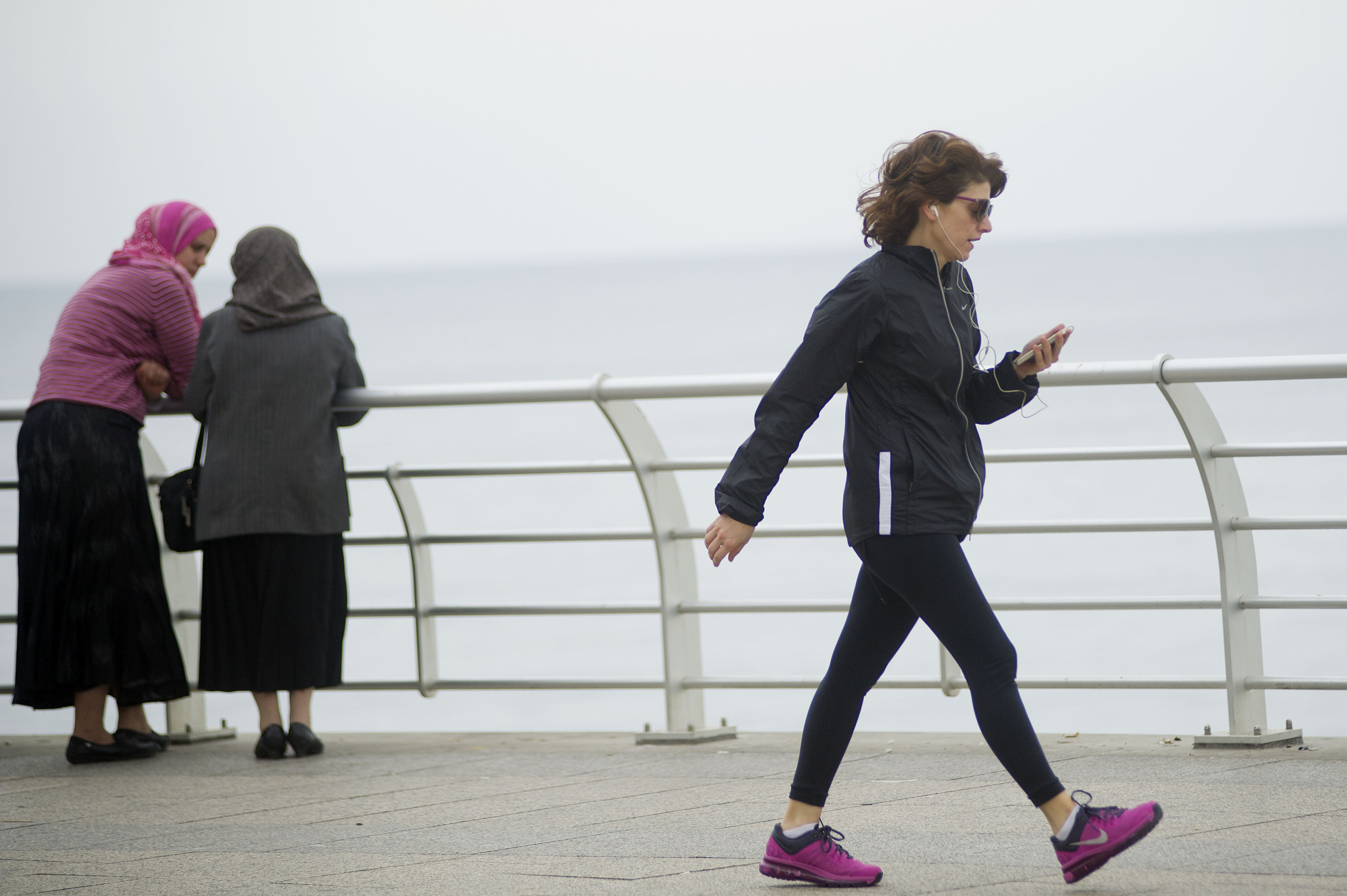 GR31207 A woman checks her smartphone while exercising
