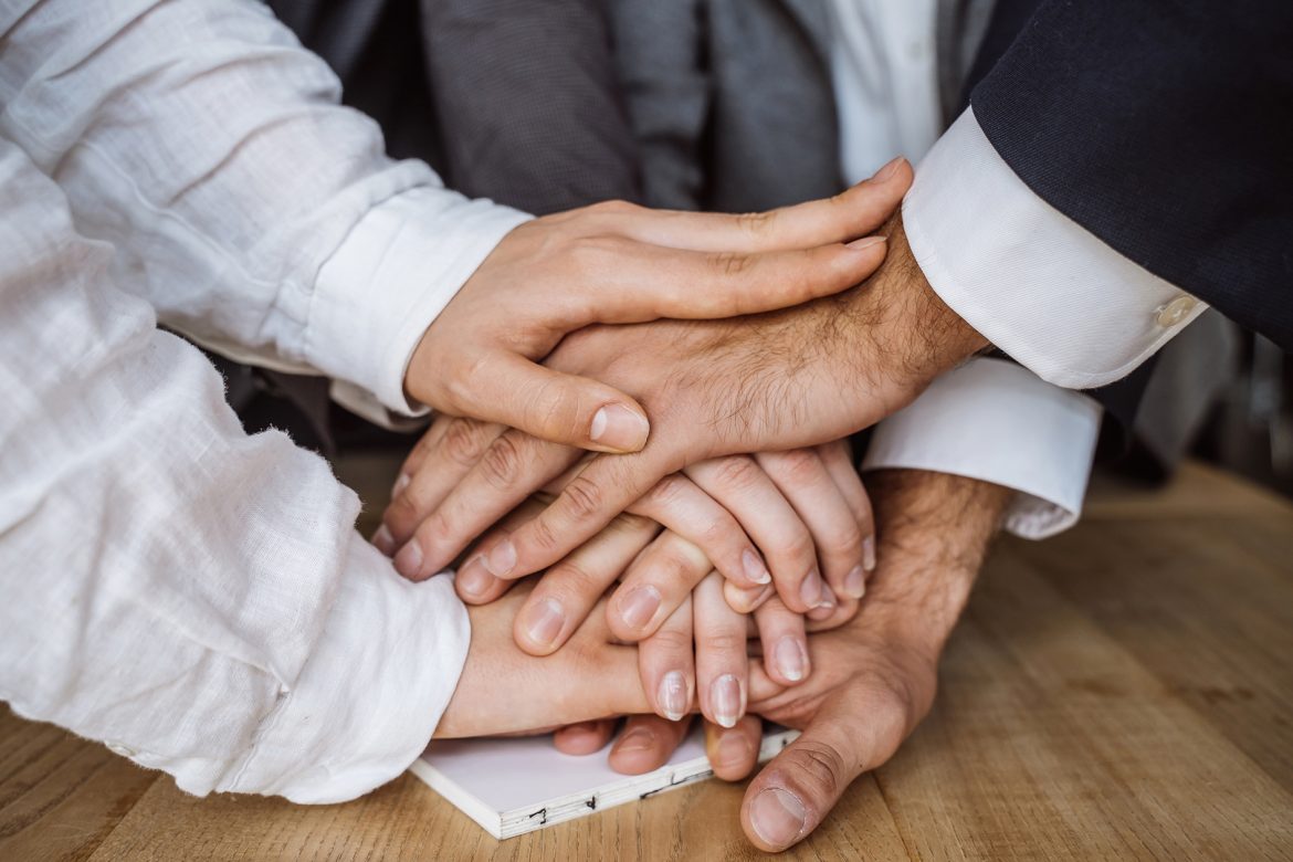 United hands of business team on workspace background